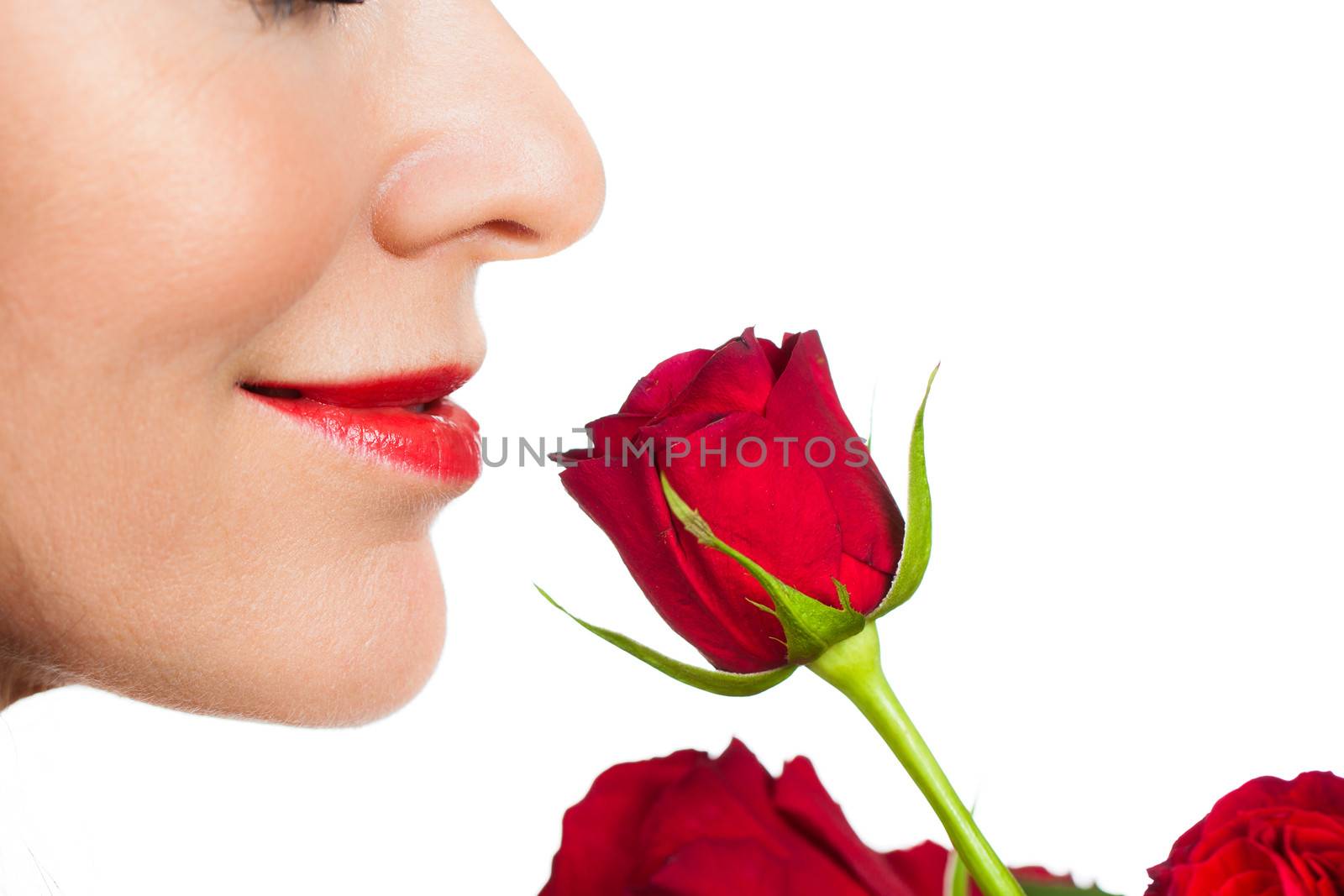 Close-up profile shot of a beautiful woman smelling a rose. Isolated on white.