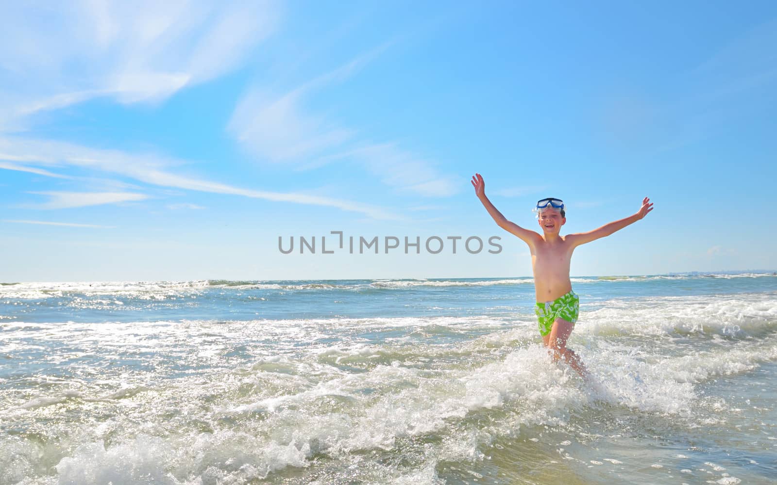 boy playing in water against the waves