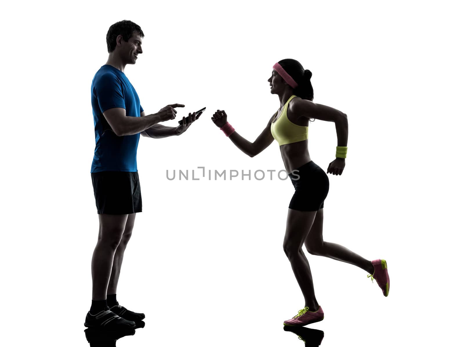 one woman exercising jogging with man coach using digital tablet in silhouette on white background