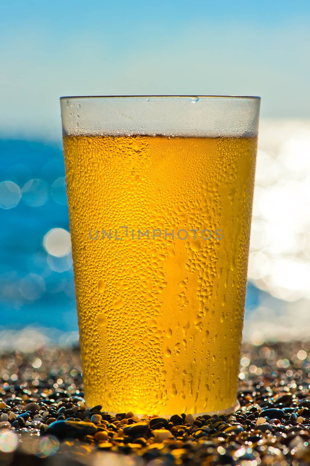 water drops on a glass of cold beer on the beach