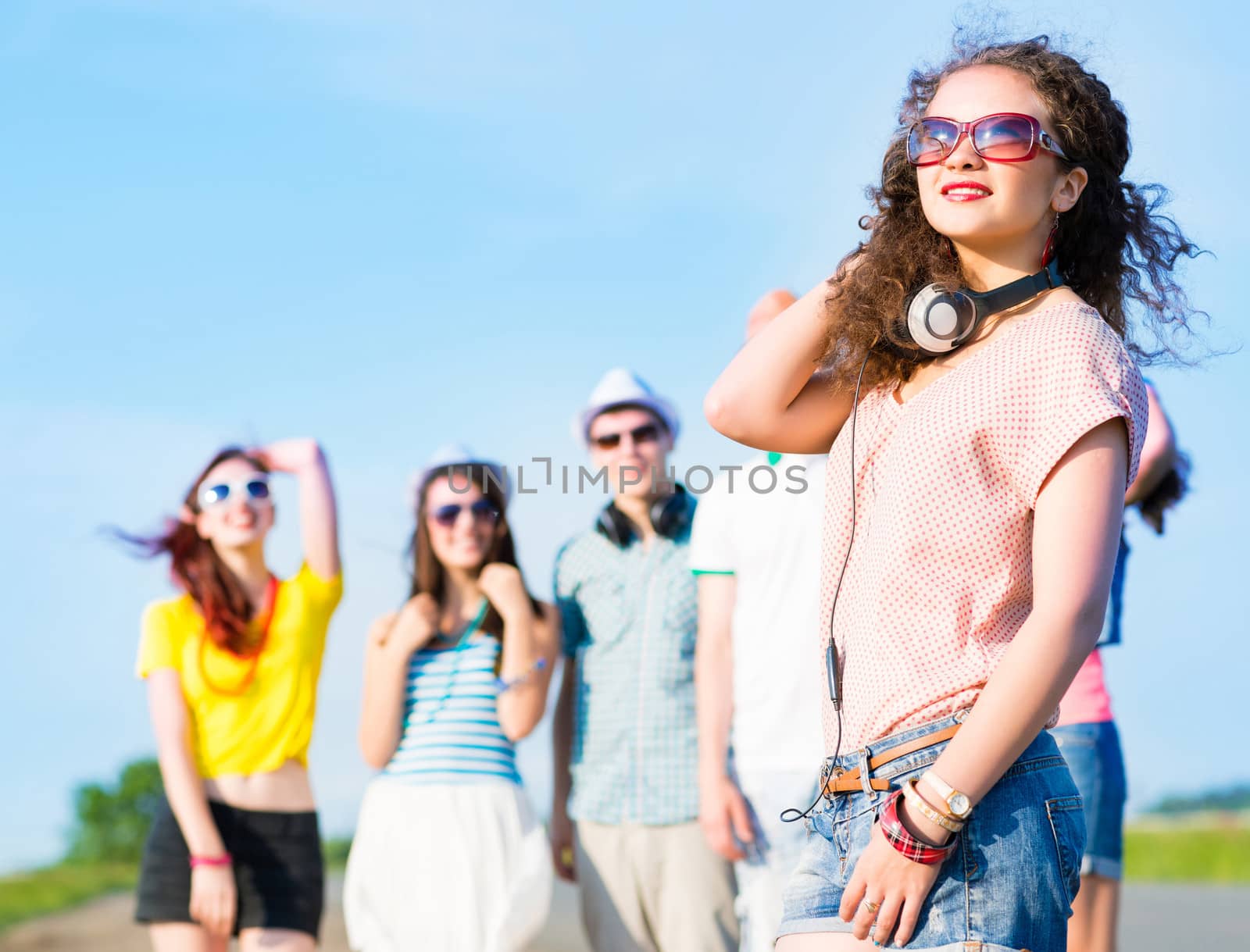 young woman with headphones on a background of blue sky and funny friends