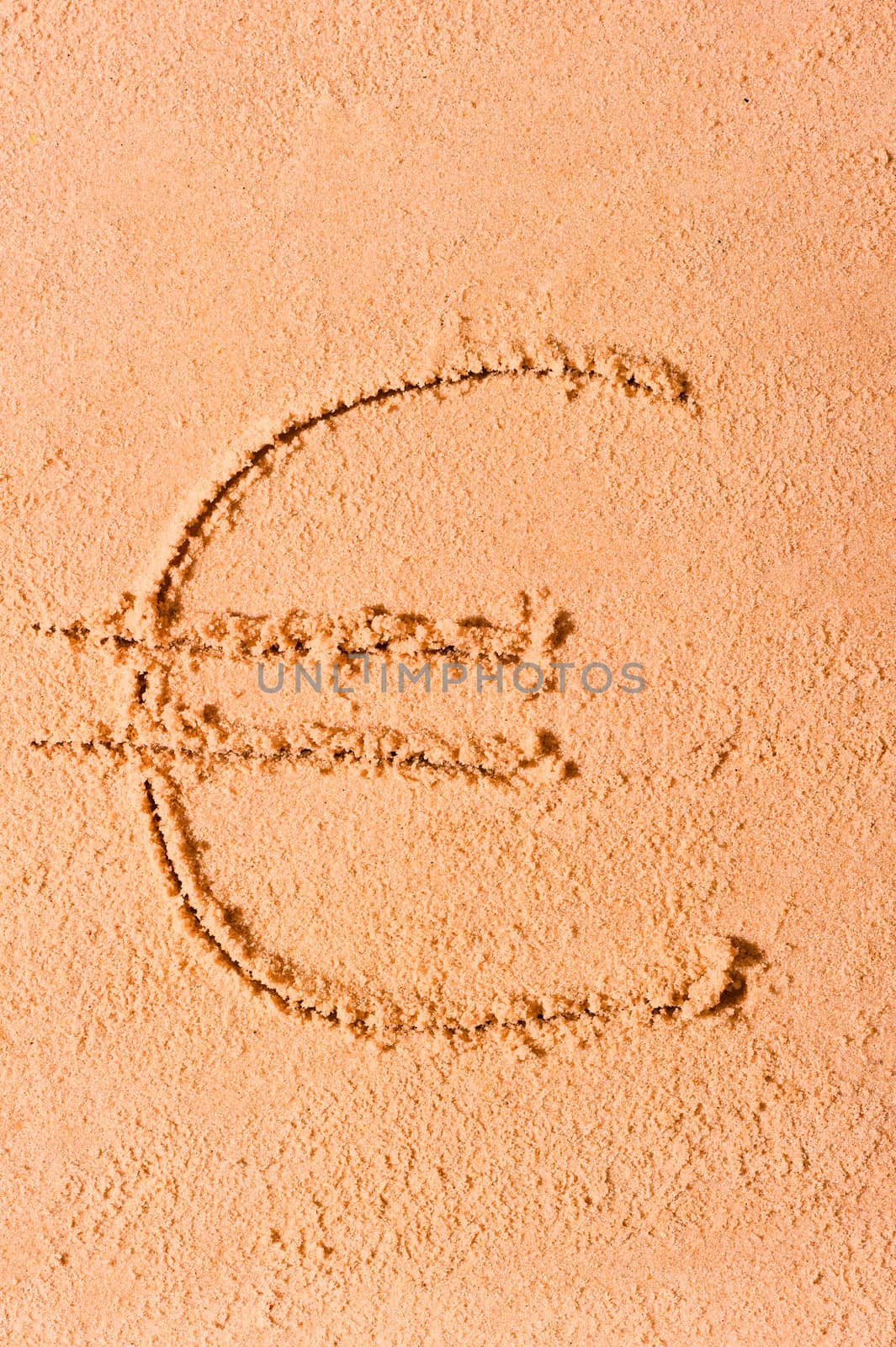 euro currency symbol is drawn on wet sand on the beach