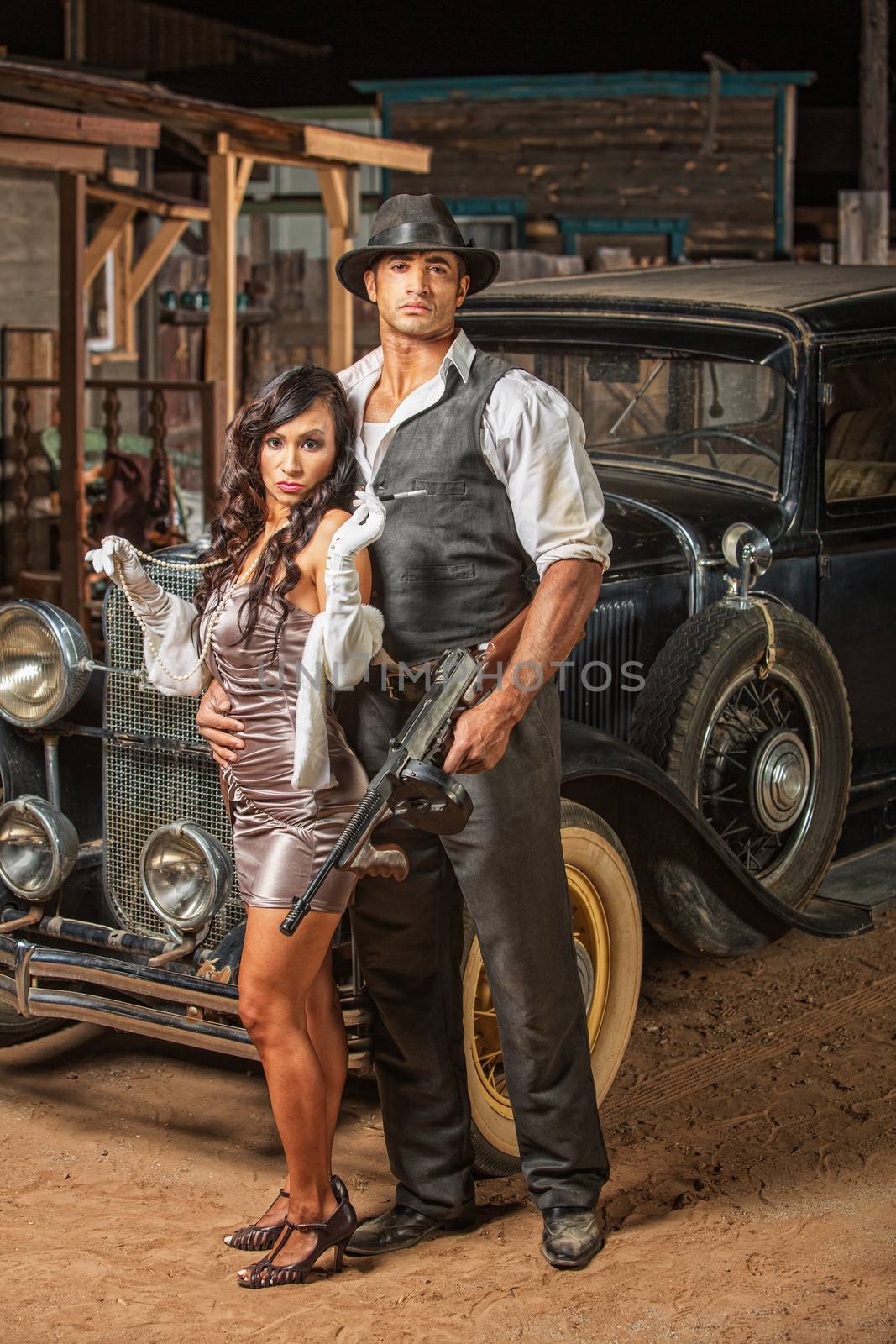 Handsome muscular 1920s gangster with lady in mini skirt