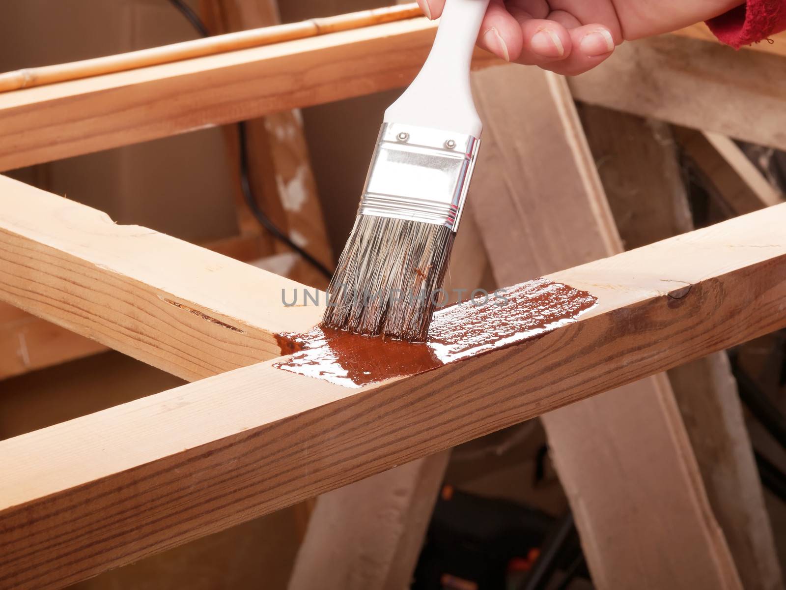 applying protective primer on wooden rack