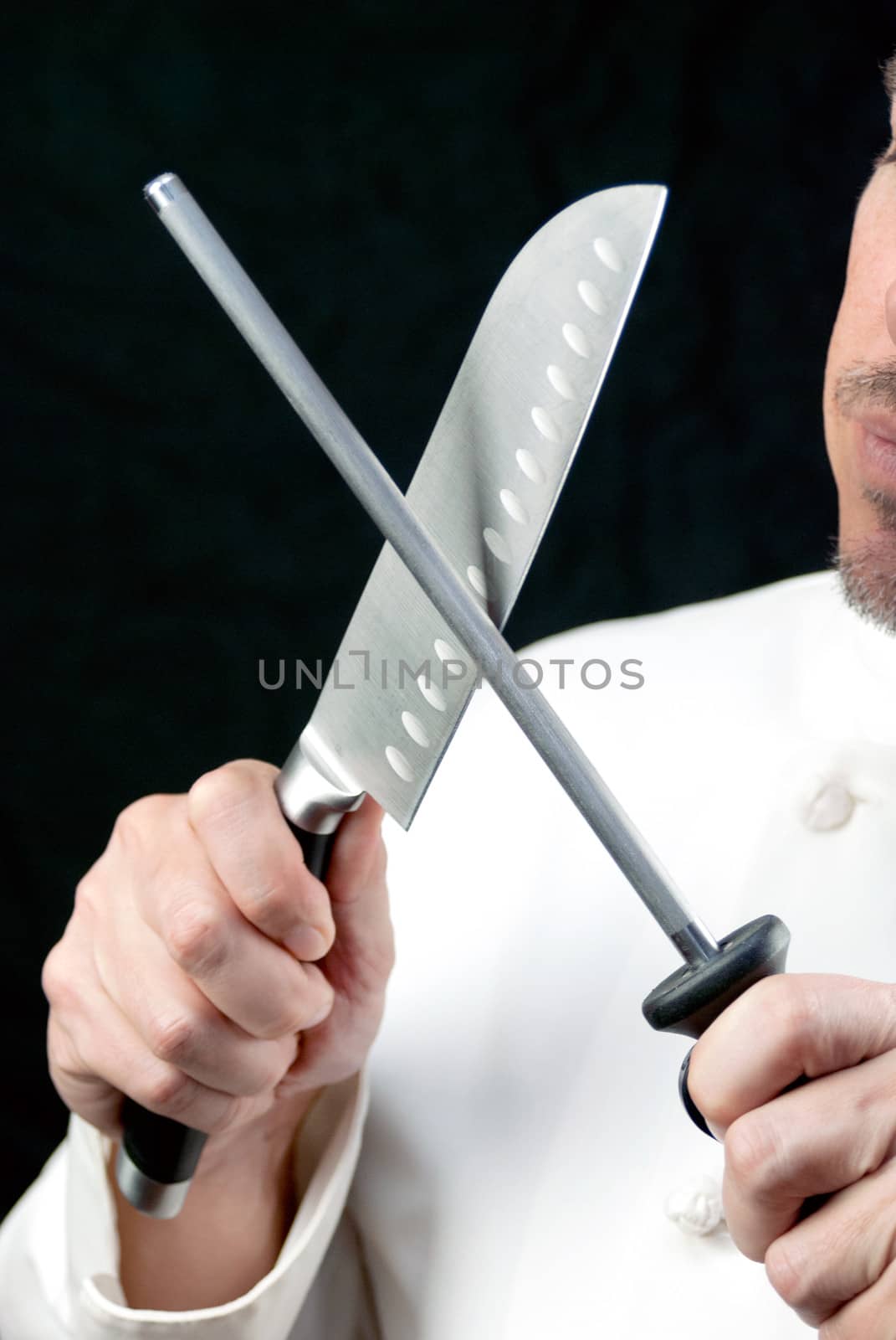 Close-up of a chef sharpening his knife, side.