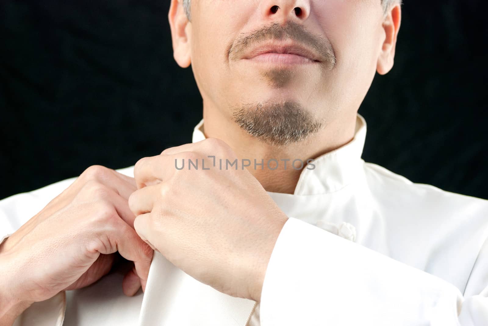 Close-up of a chef doing up his jacket.