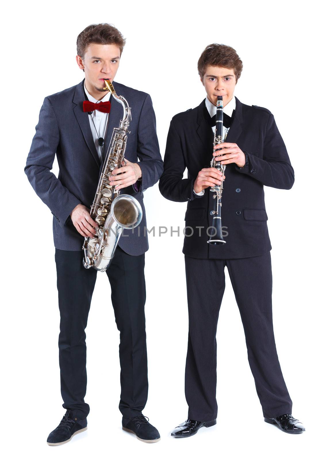 Young mans in a suit playing on saxophone and clarinet. Isolated on background