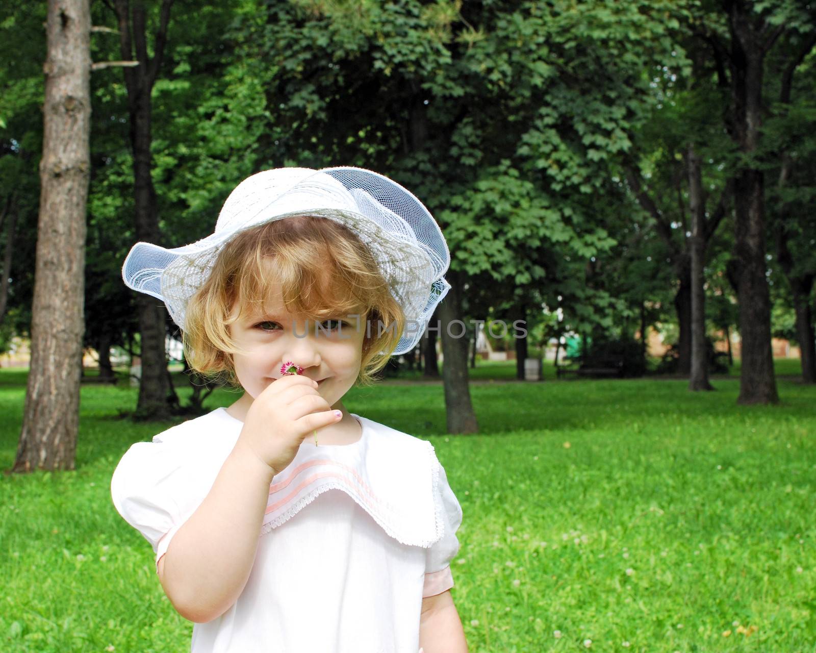 beautiful little girl in white dress and hat spring season