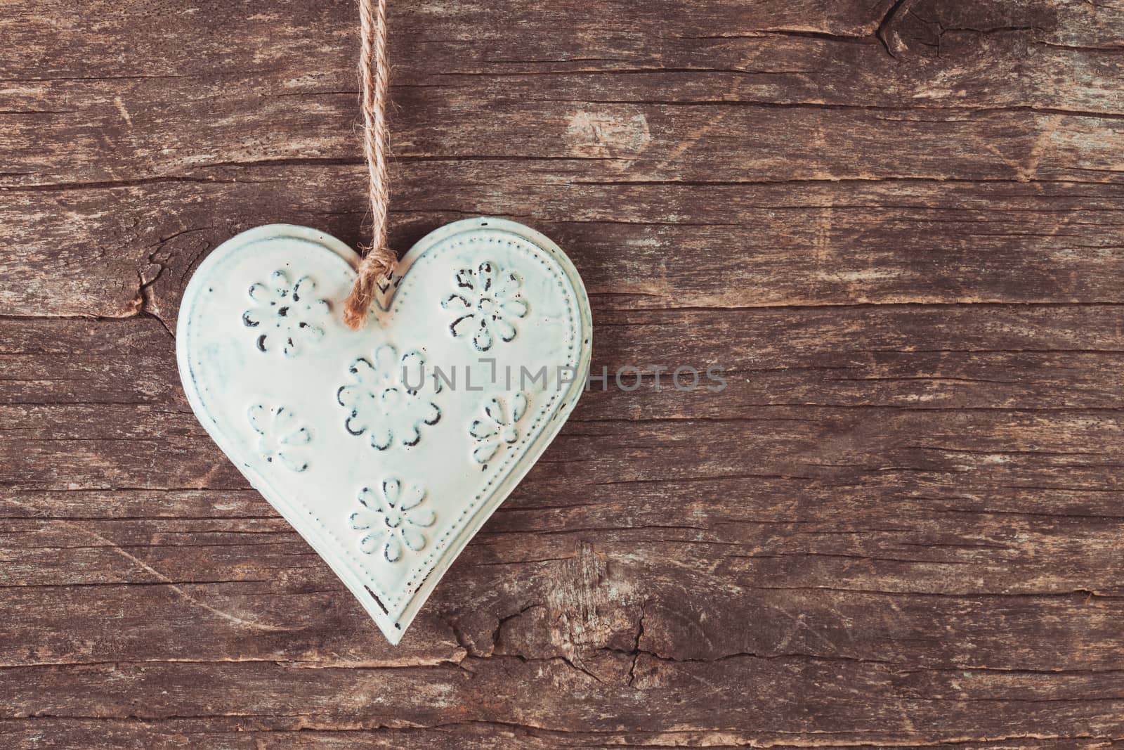 Metal heart on the old wooden background