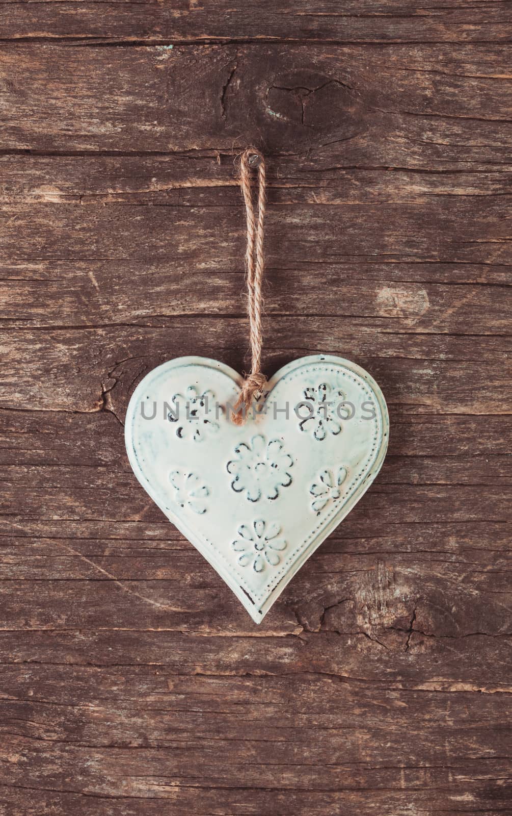 Metal heart on the shabby wooden background