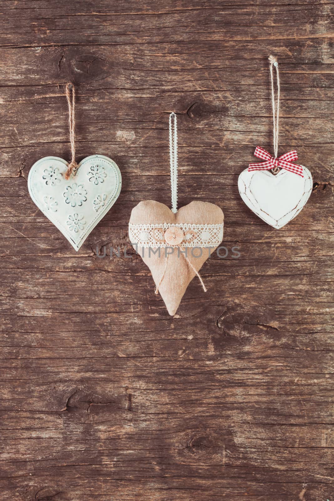 Metal, textile and wooden heart on the old natural background