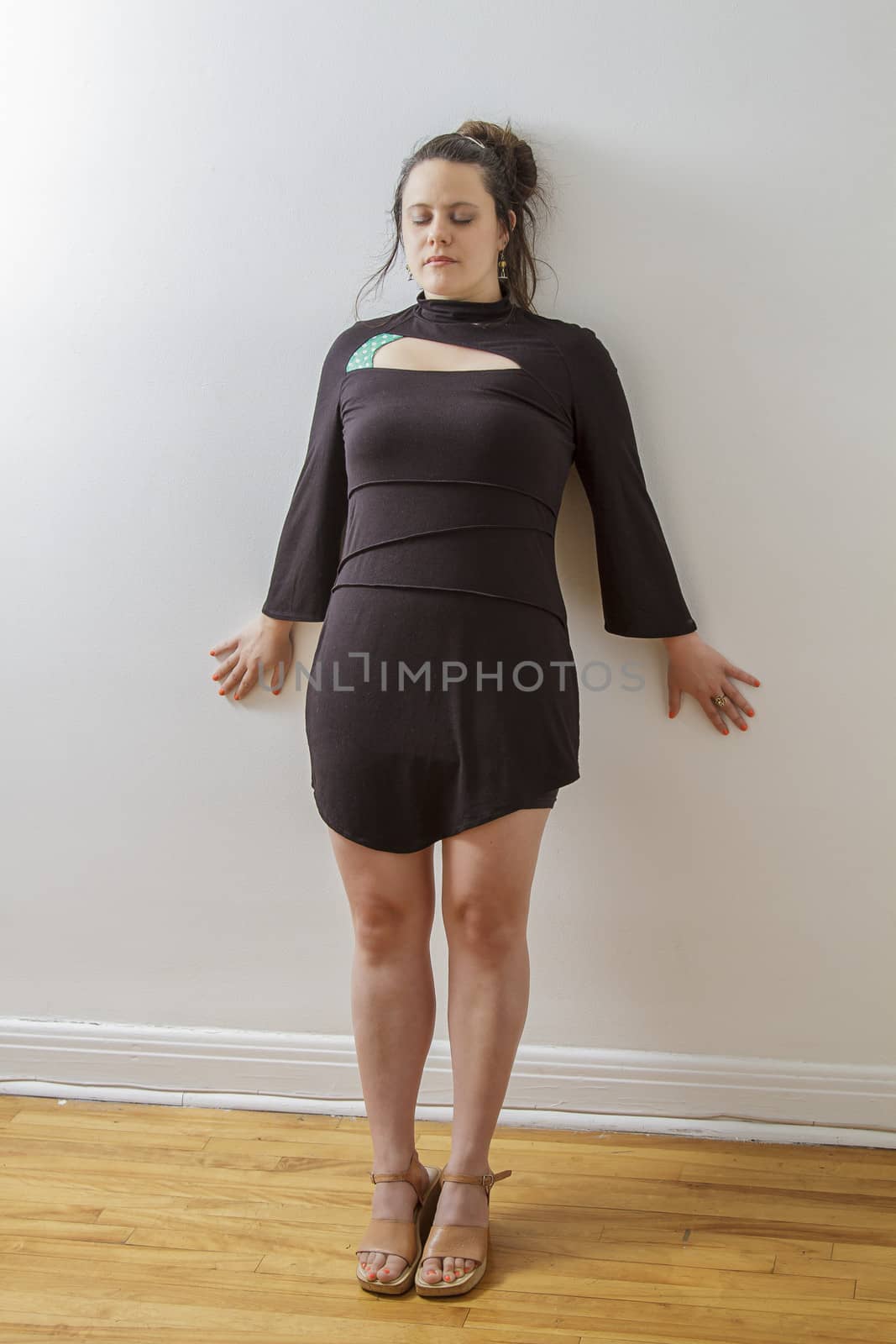 woman in her thirties, leaning against a wall