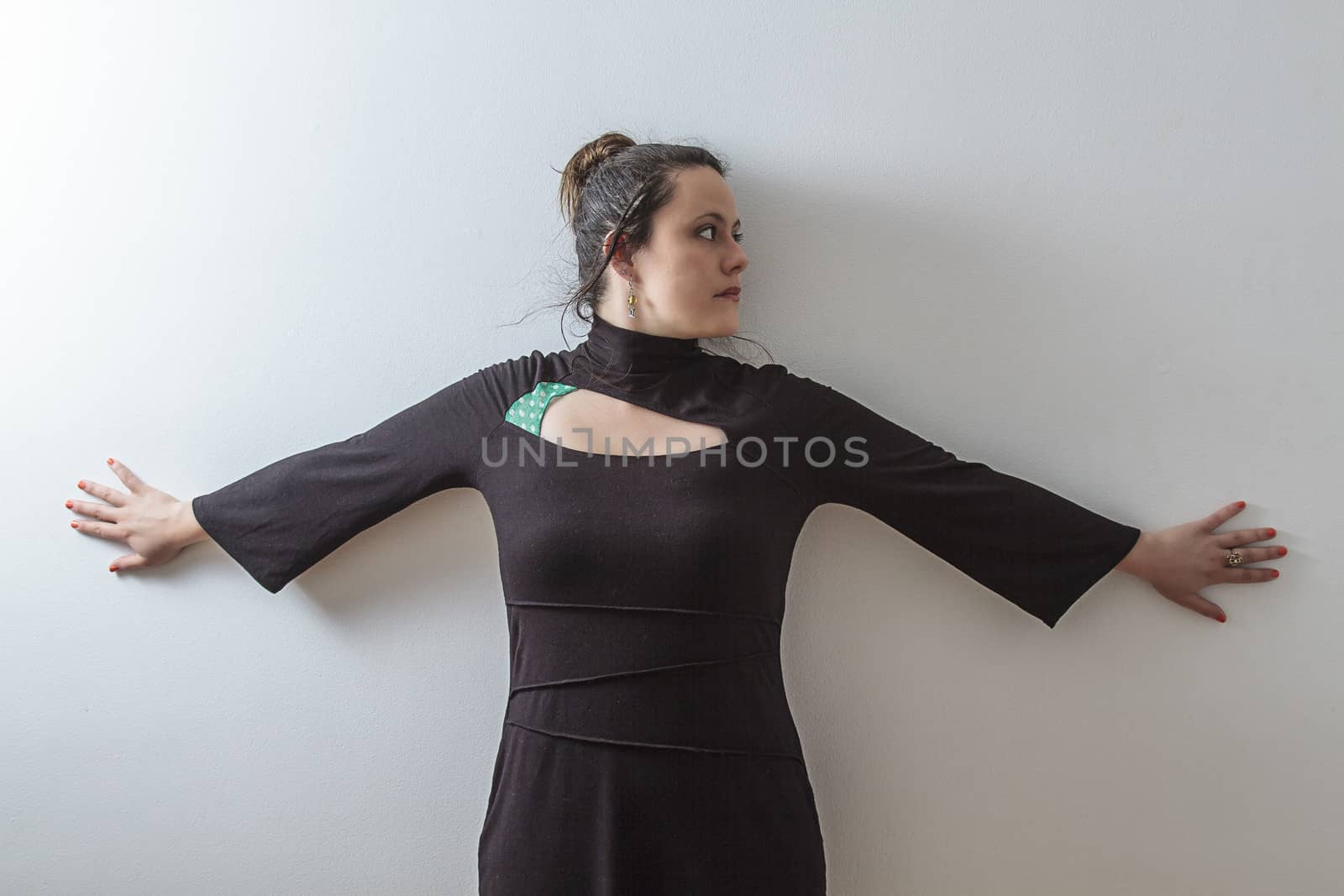 mid-thirties woman with arms as cross against a wall