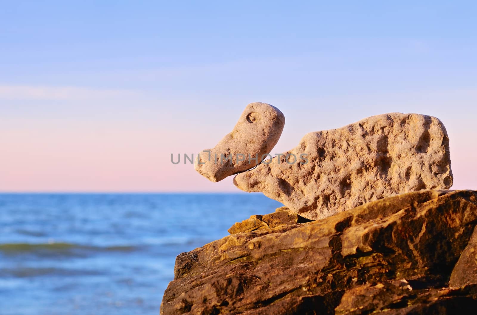 Bird-shaped stones on the top of coastal boulder