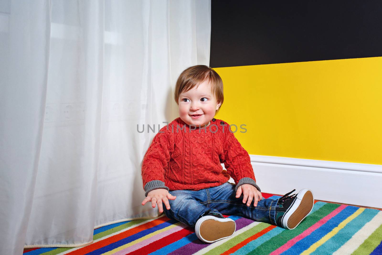 Cute little boy sitting on the floor in the living room