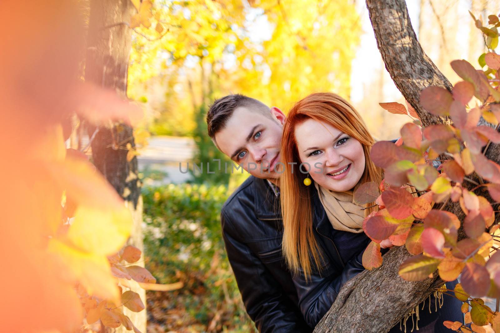 Young couple peeking from behind tree by Vagengeym