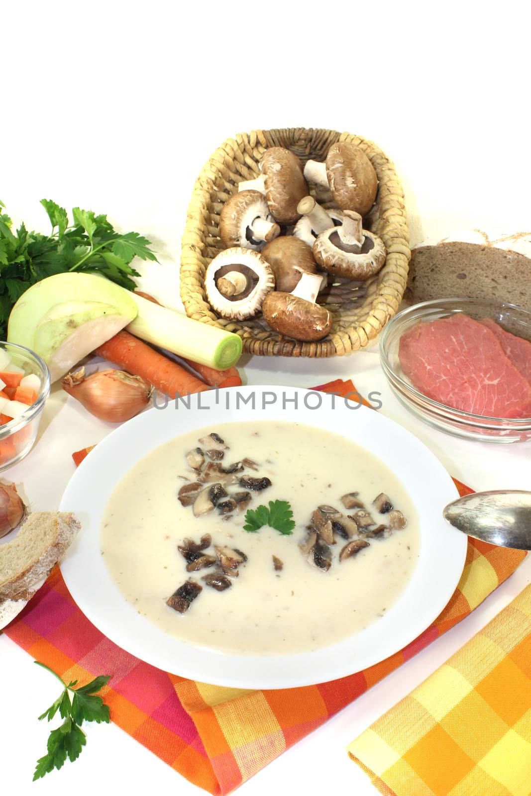 Veal cream soup with mushrooms and parsley on a light background