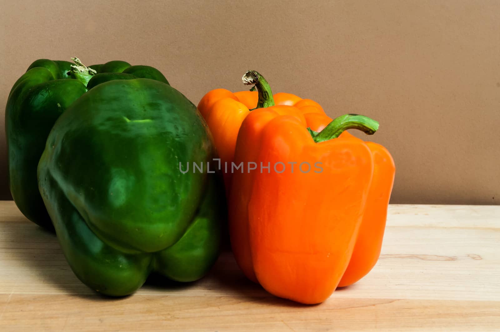 Four Sweet Green and Orange Peppers on a cutting board