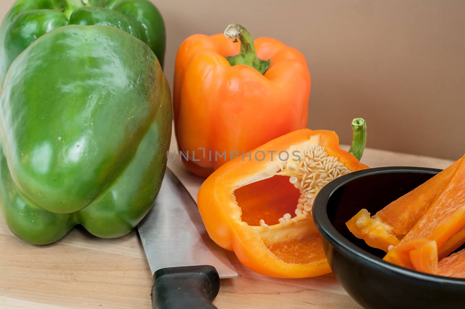 Green and Sliced Orange Pepper on a cutting board