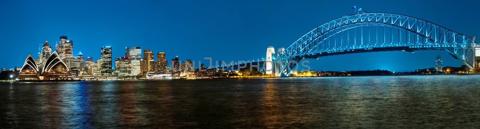 Panoramic photo of Sydney skyline with Harbour Bridge in the evening after sunset