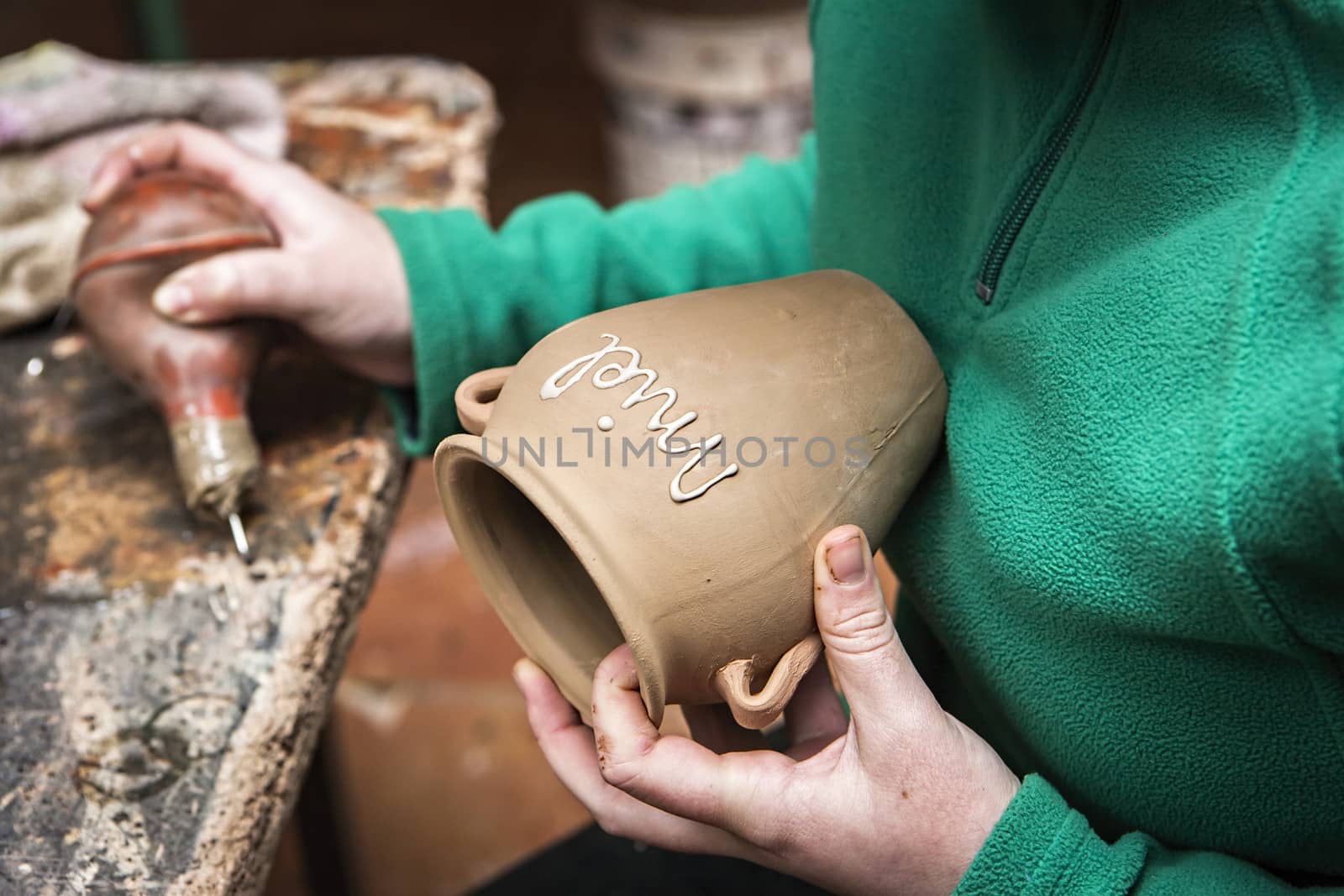Potter decorating a ceramic jar with the word honey, clay pottery ceramics typical of Bailen, Jaen province, Andalucia, Spain