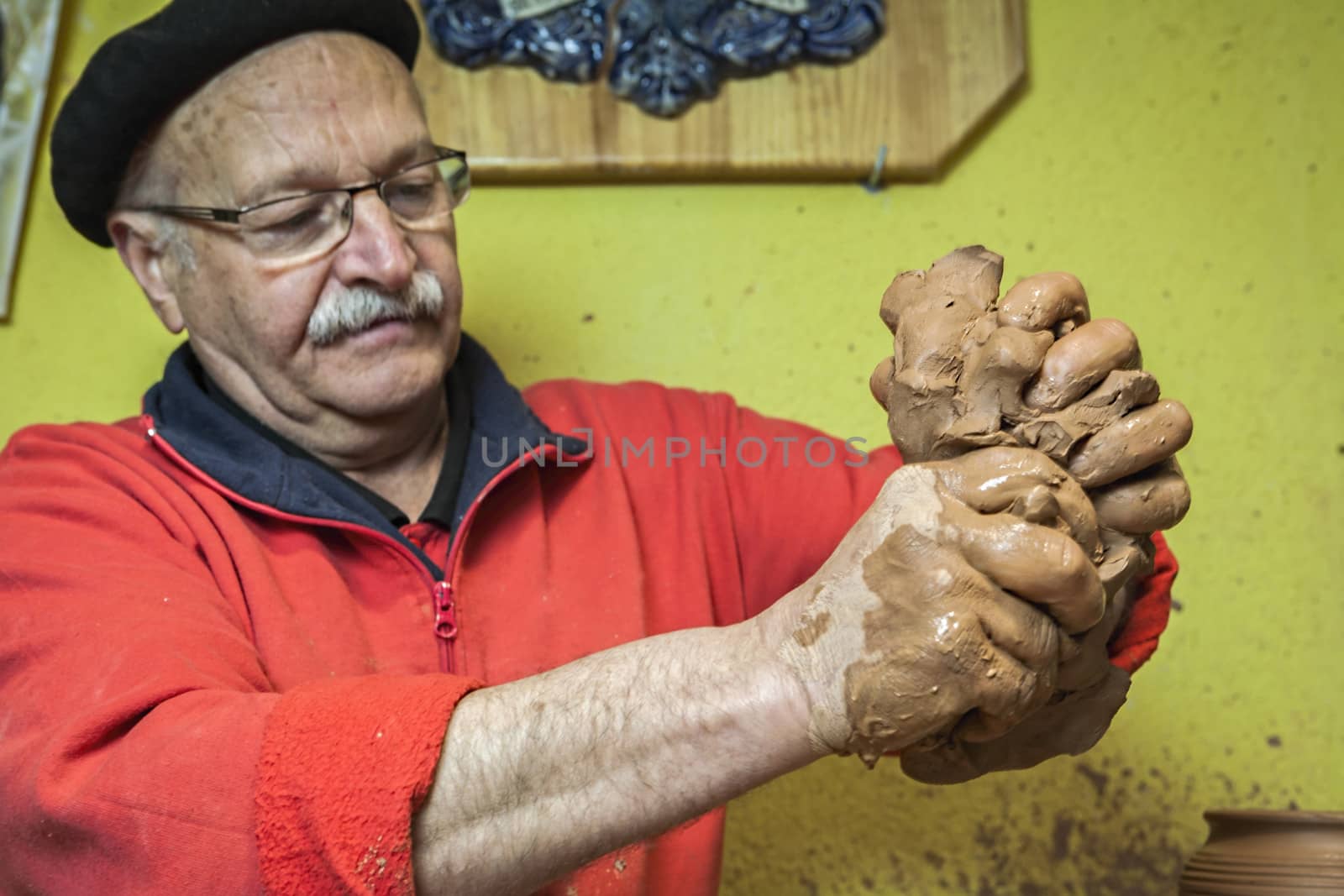 Potter preparing a piece of clay to start working by digicomphoto