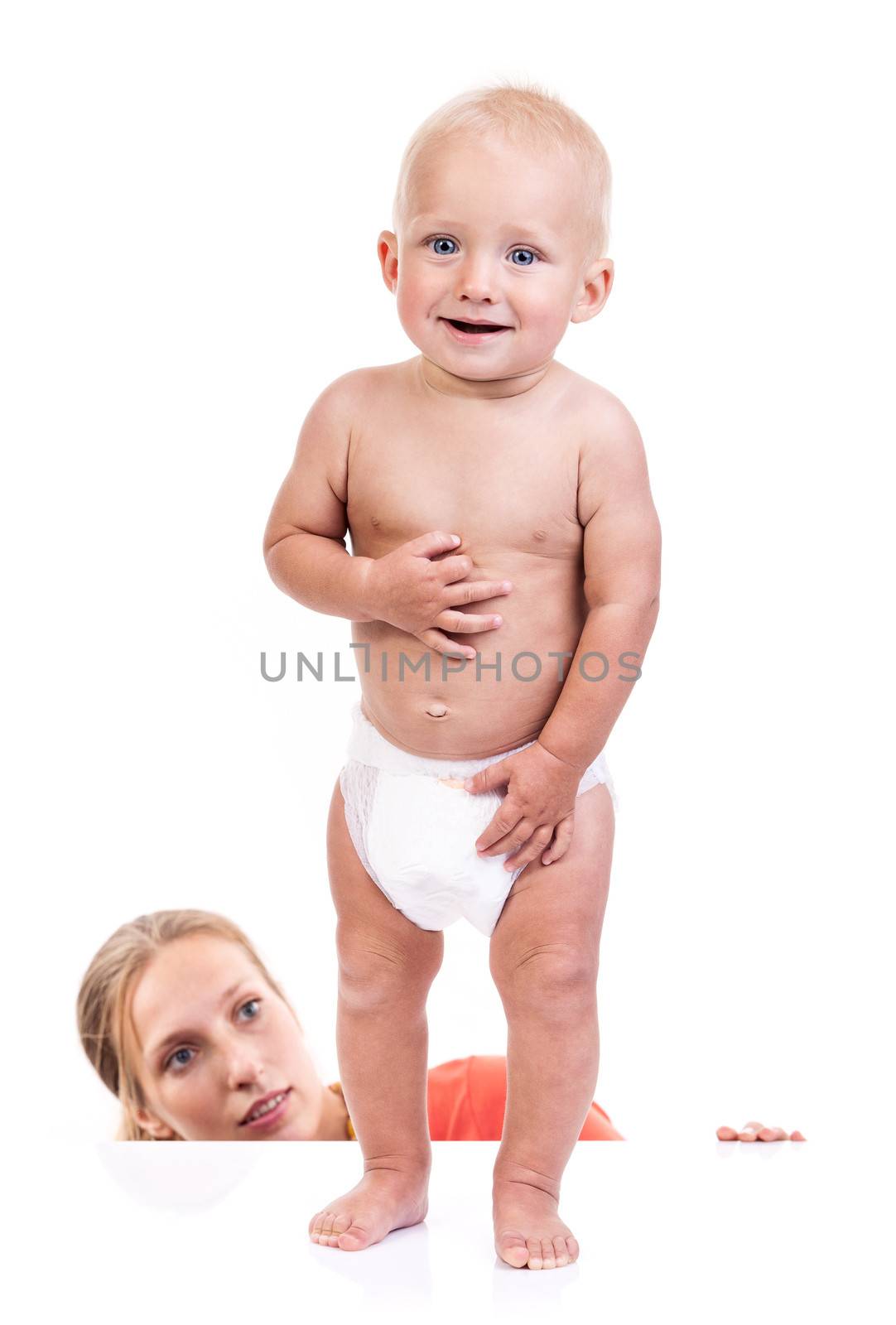 Mother watching her baby boy making first steps over white background
