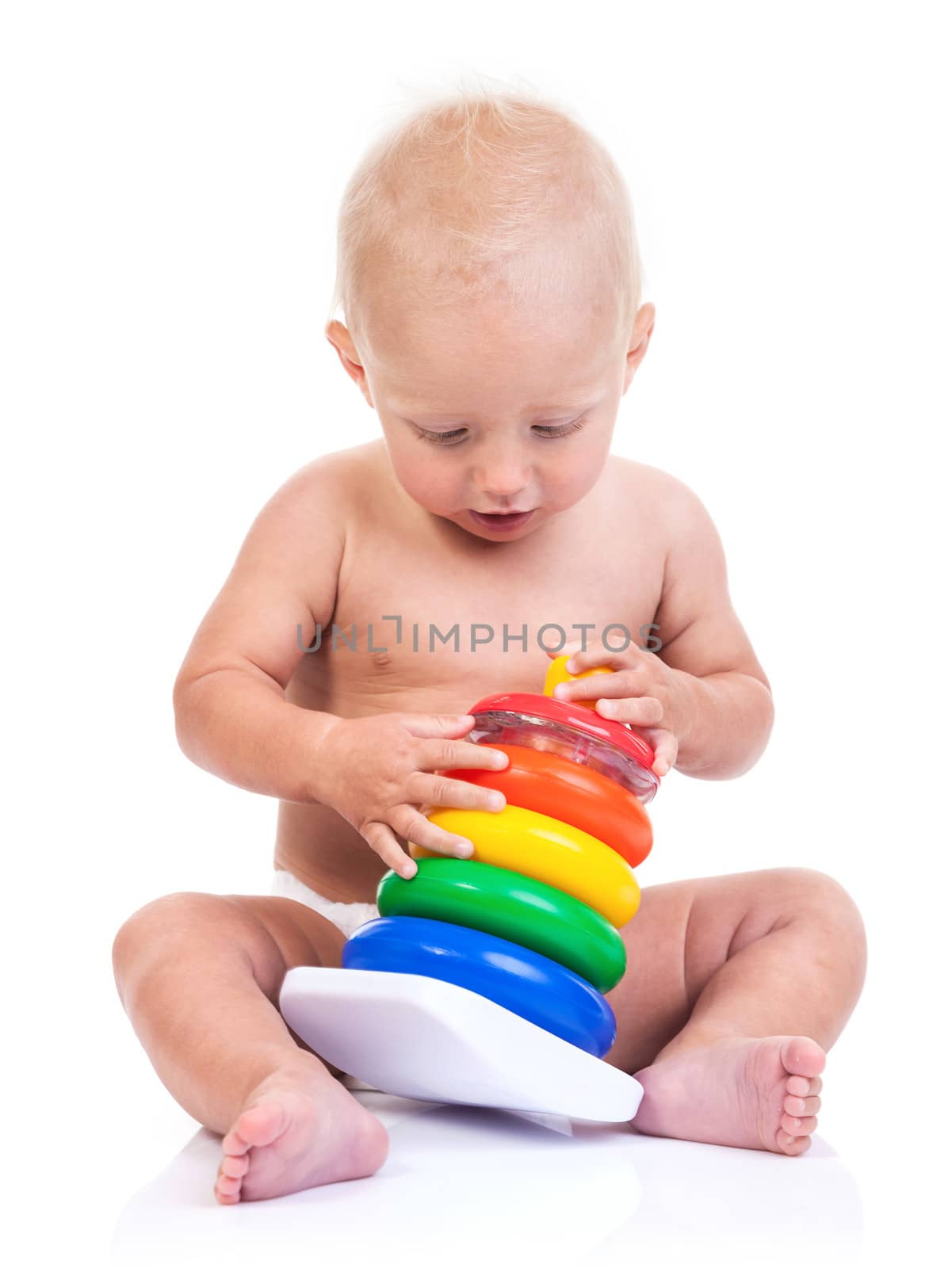 Cute little boy playing with pyramid toy on white by photobac