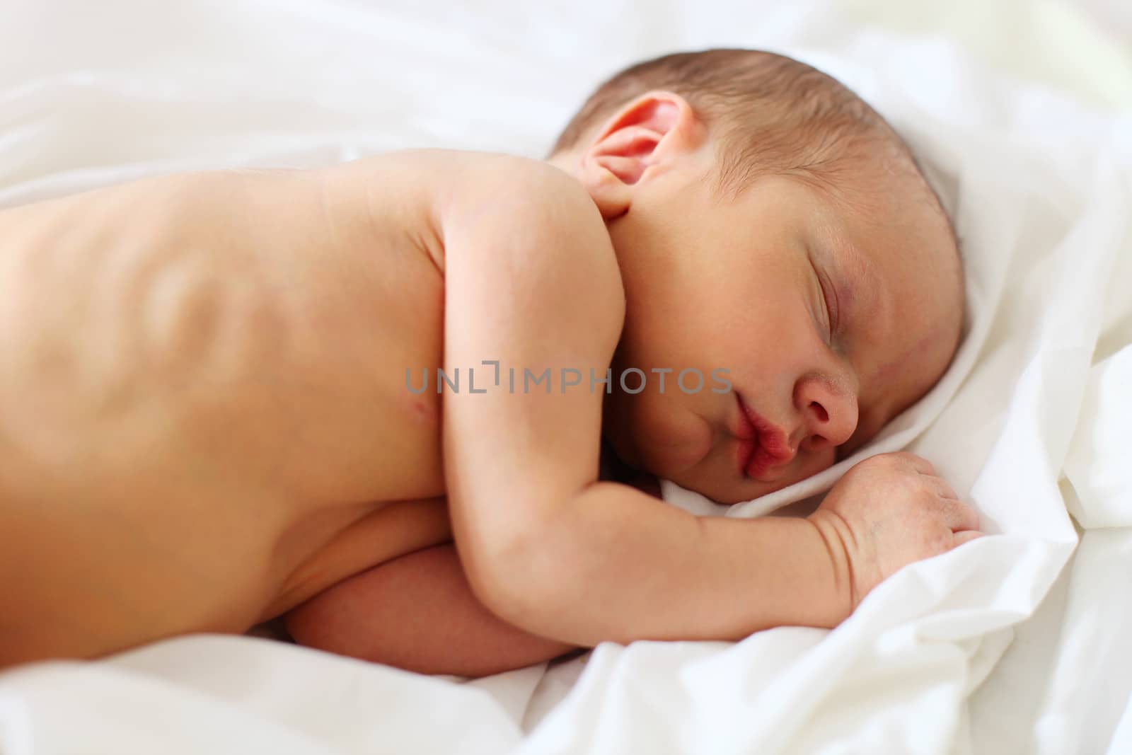 Cute three-day old baby boy asleep on bad