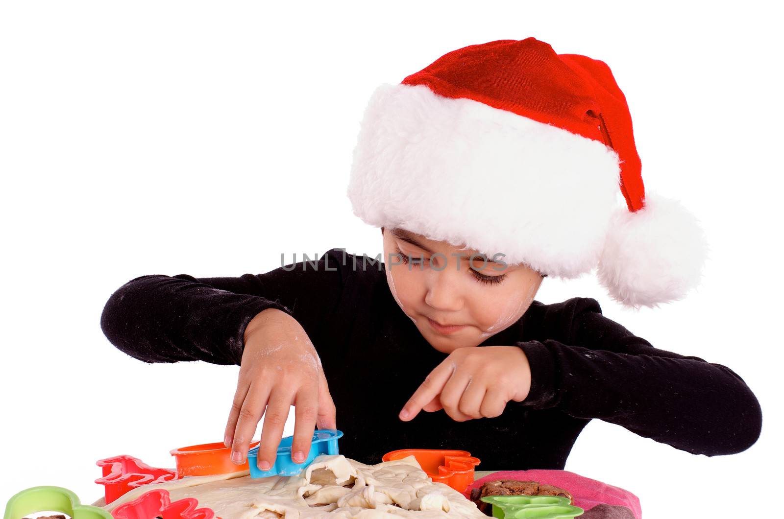 Little Boy in Santa Hat Prepared Dough with Colored Pastry Cutters isolated on white background 