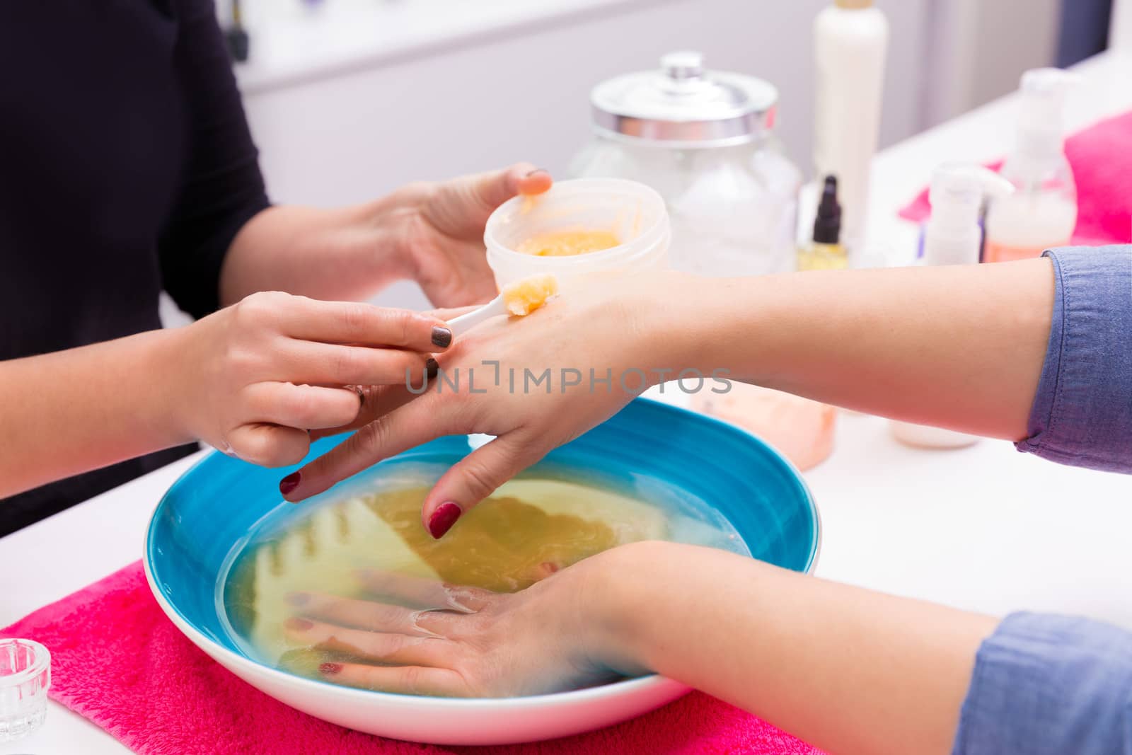 Nail saloon scrub bath exfoliant hands in bowl water by lunamarina