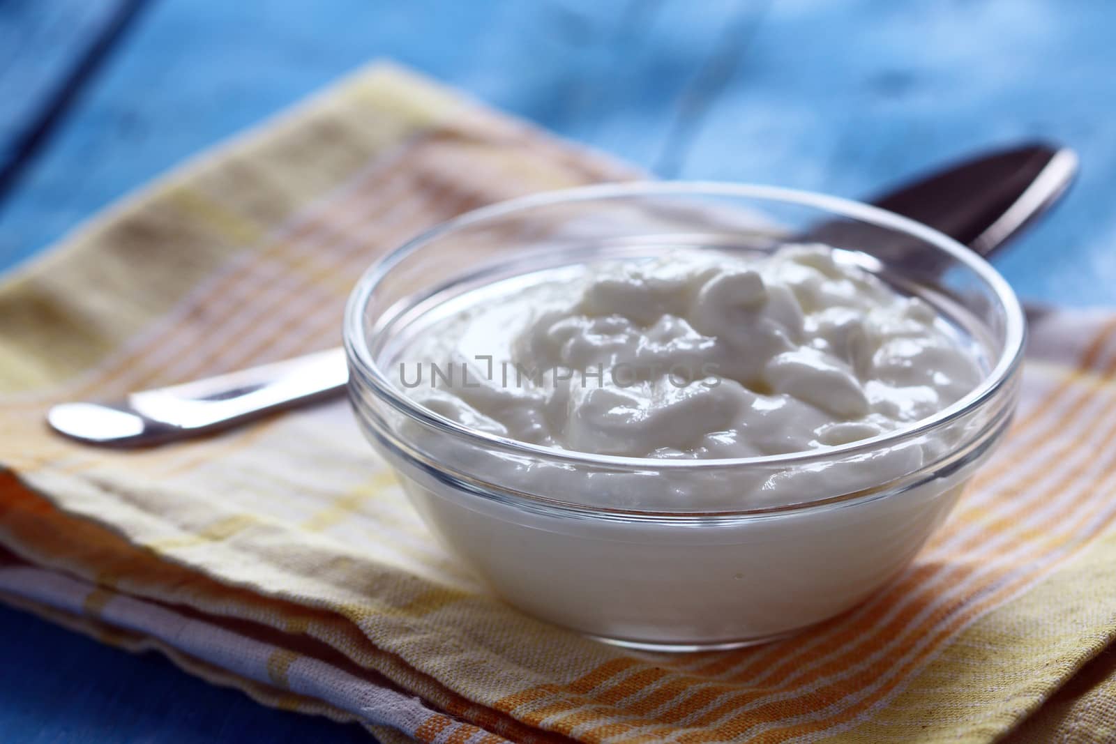 Homemade yogurt in a glass bowl and spoon