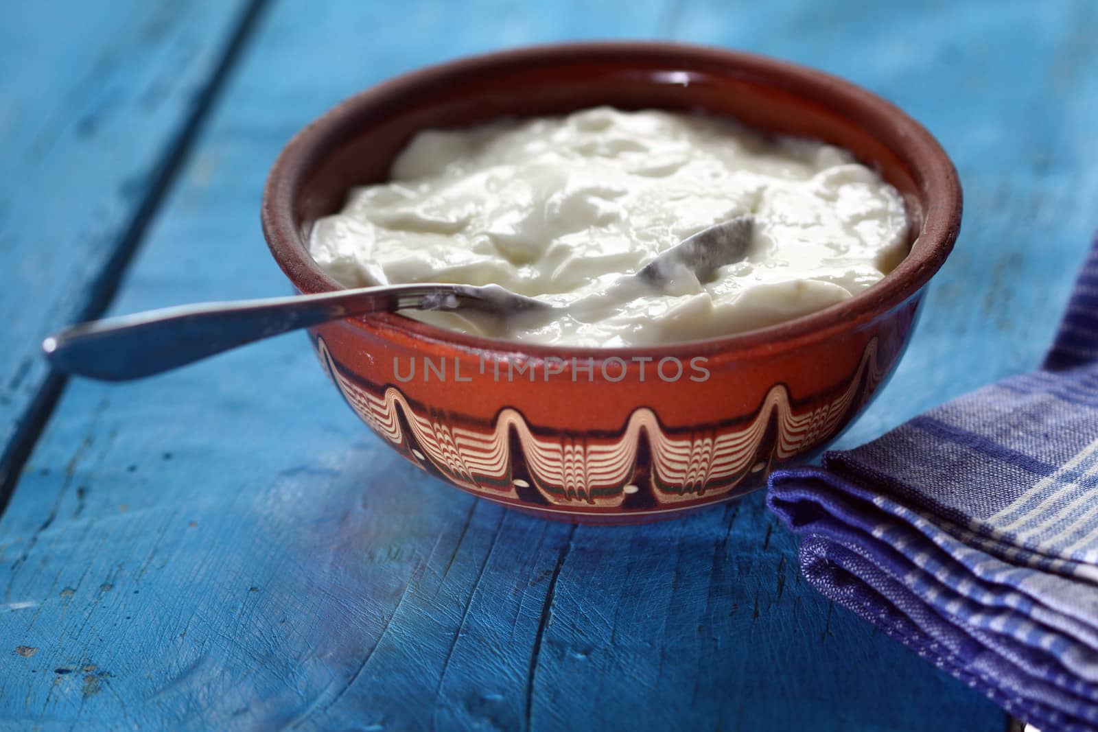 Homemade yogurt in a ceramic bowl and spoon