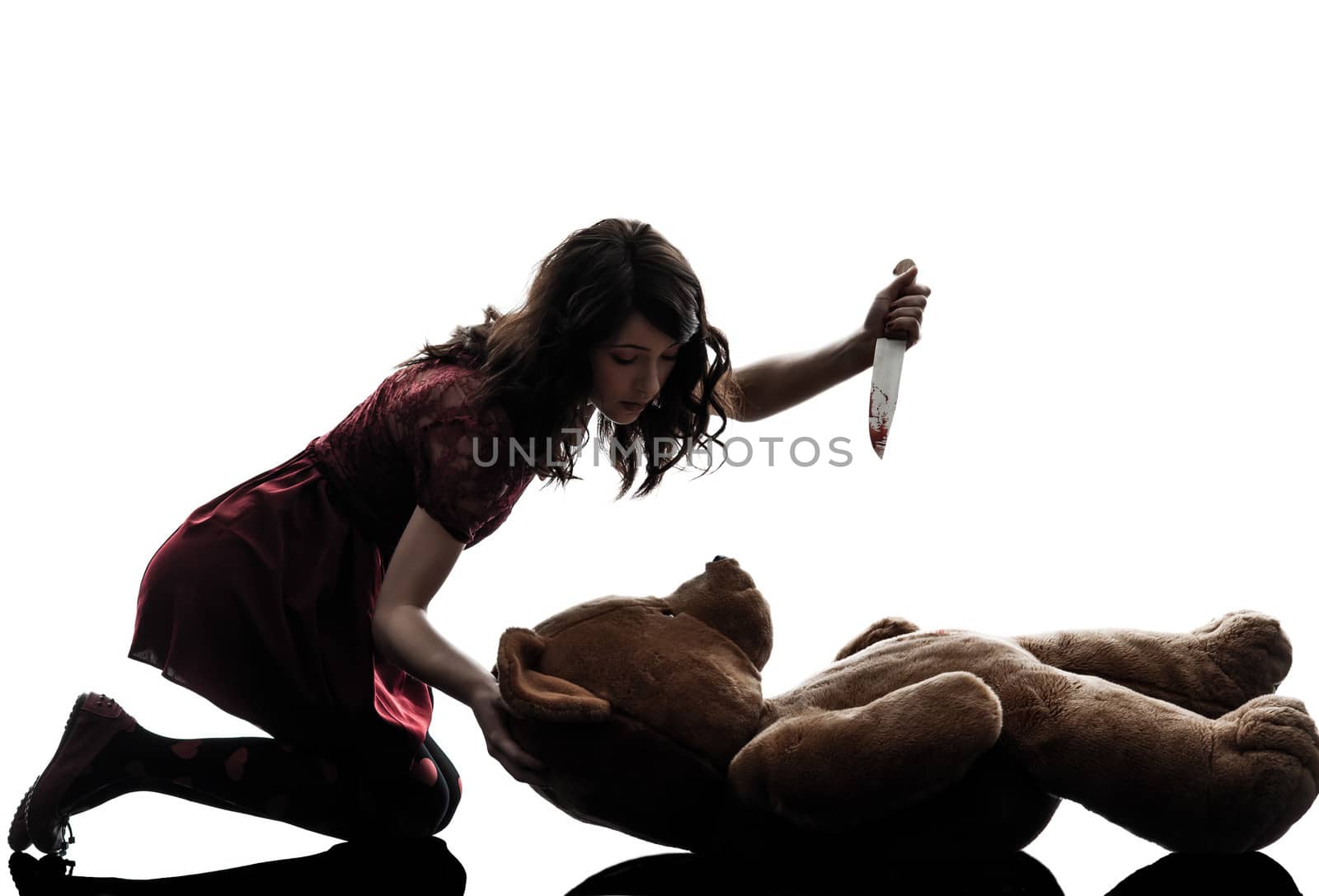 one caucasian strange young woman killing her teddy bear in silhouette white background