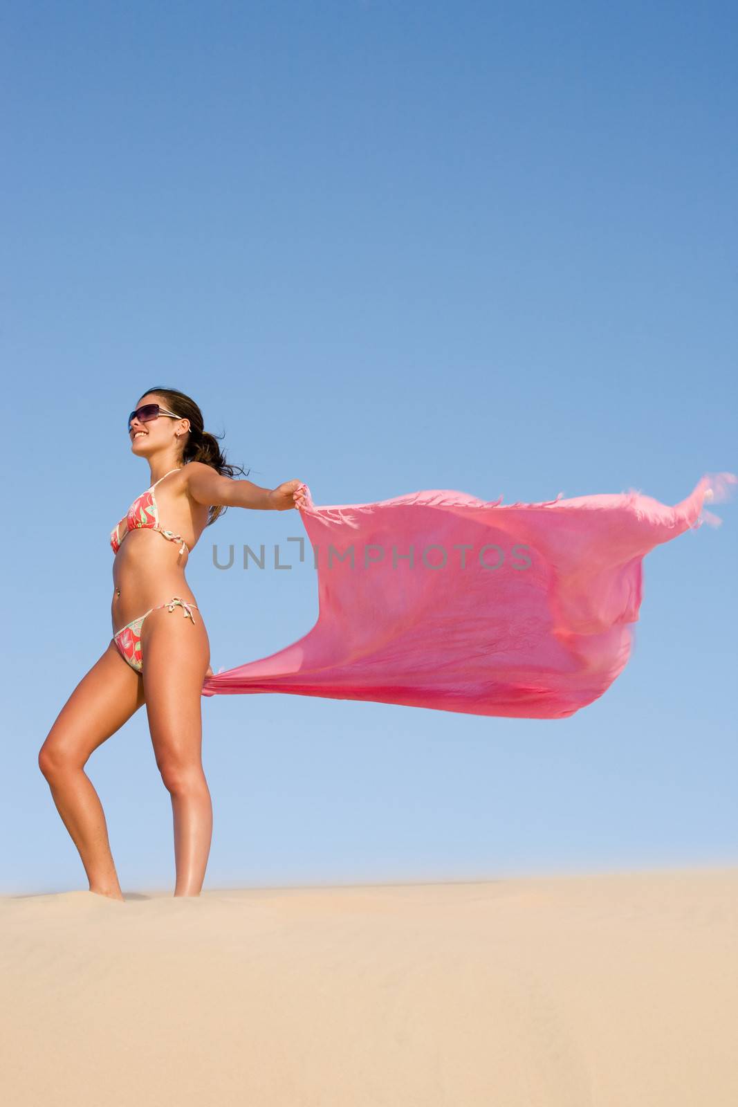 woman in the wind of the sand dune of jericoacoara ceara state near fortaleza floating his sarong