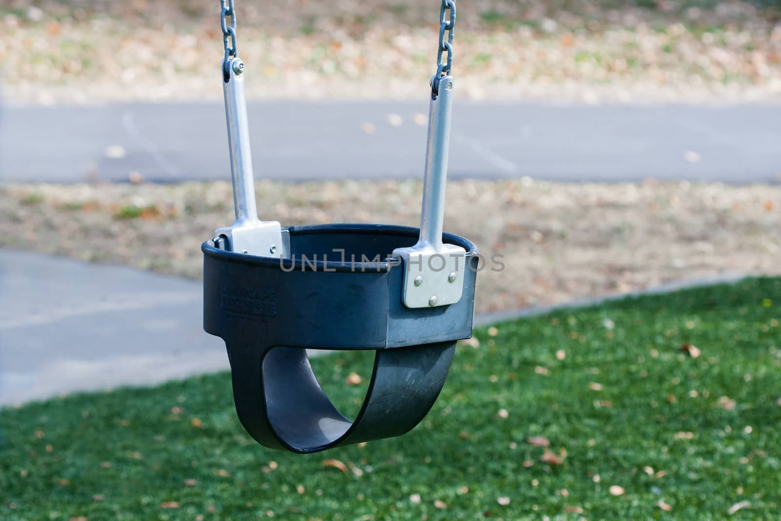 Close up of a childs swings on empty playground