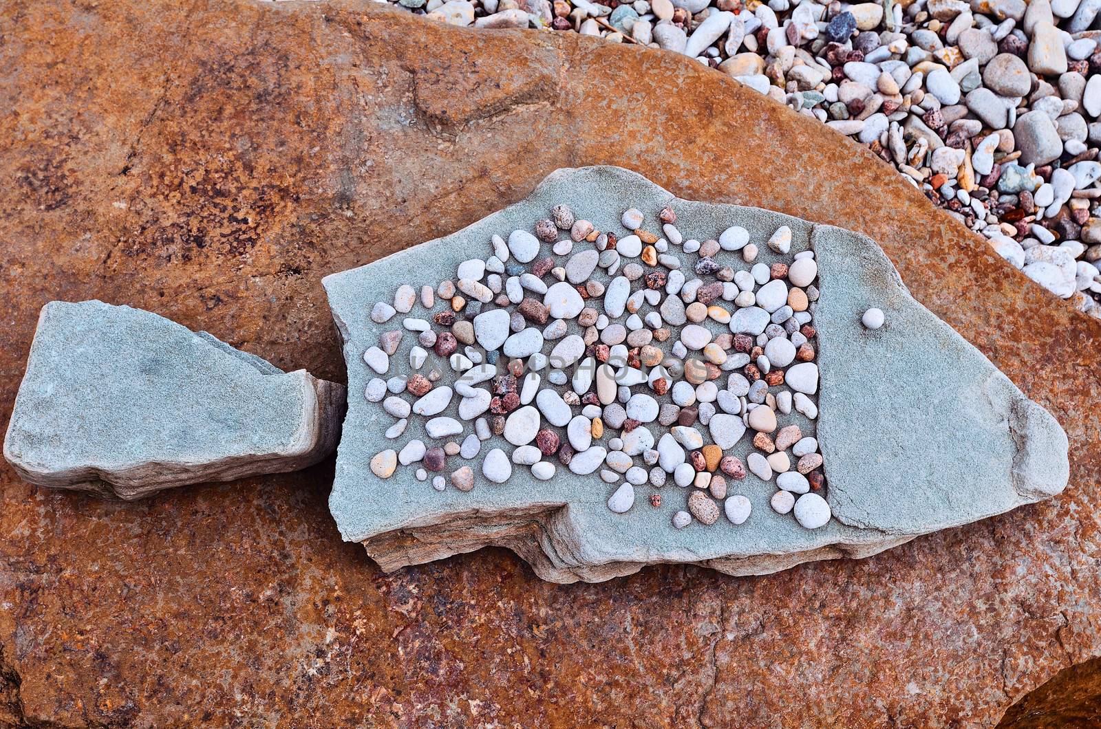 Symbol fish of sea pebbles on the beach