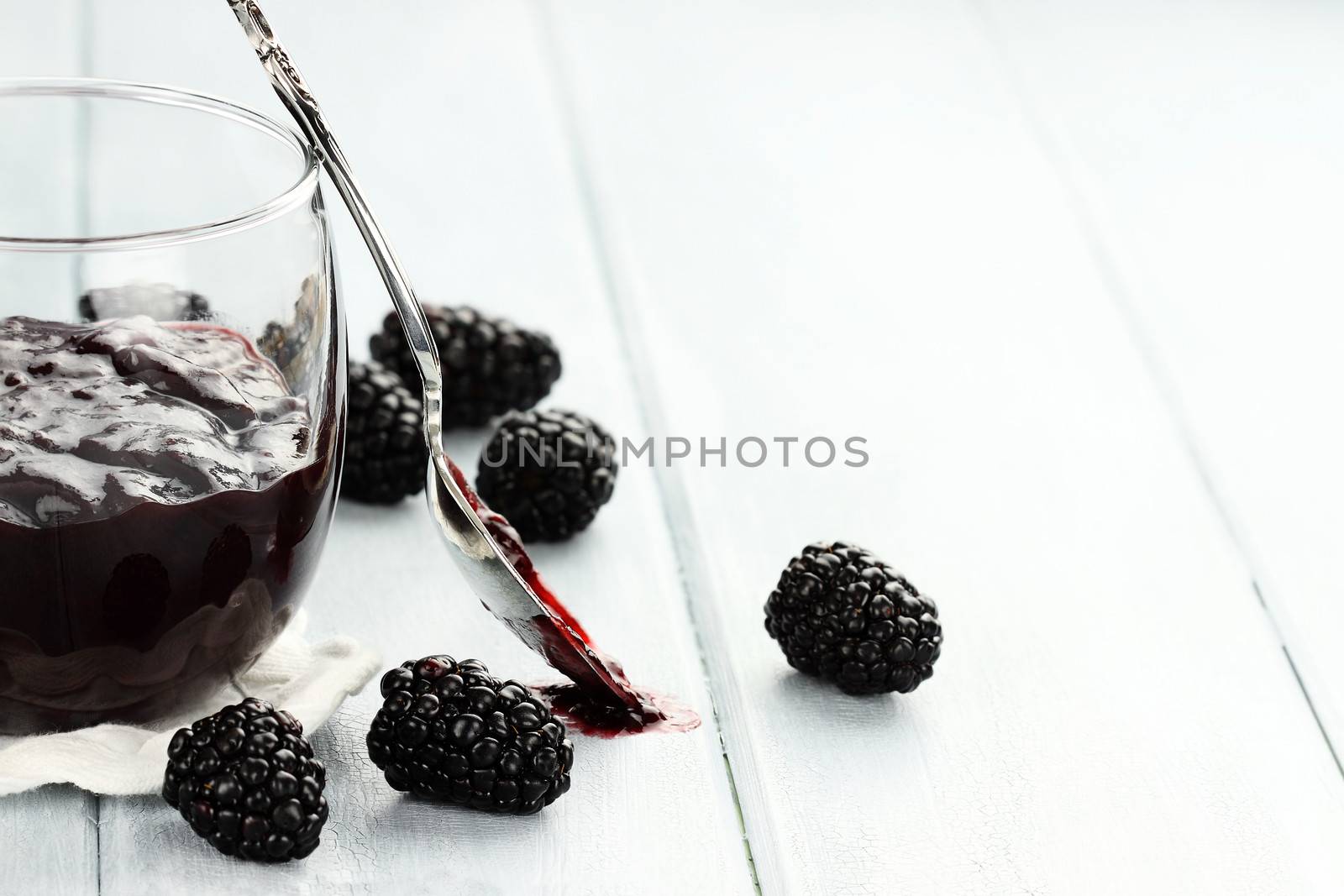 Delicious blackberry jelly and spoon with copy space. Extreme shallow depth of field.