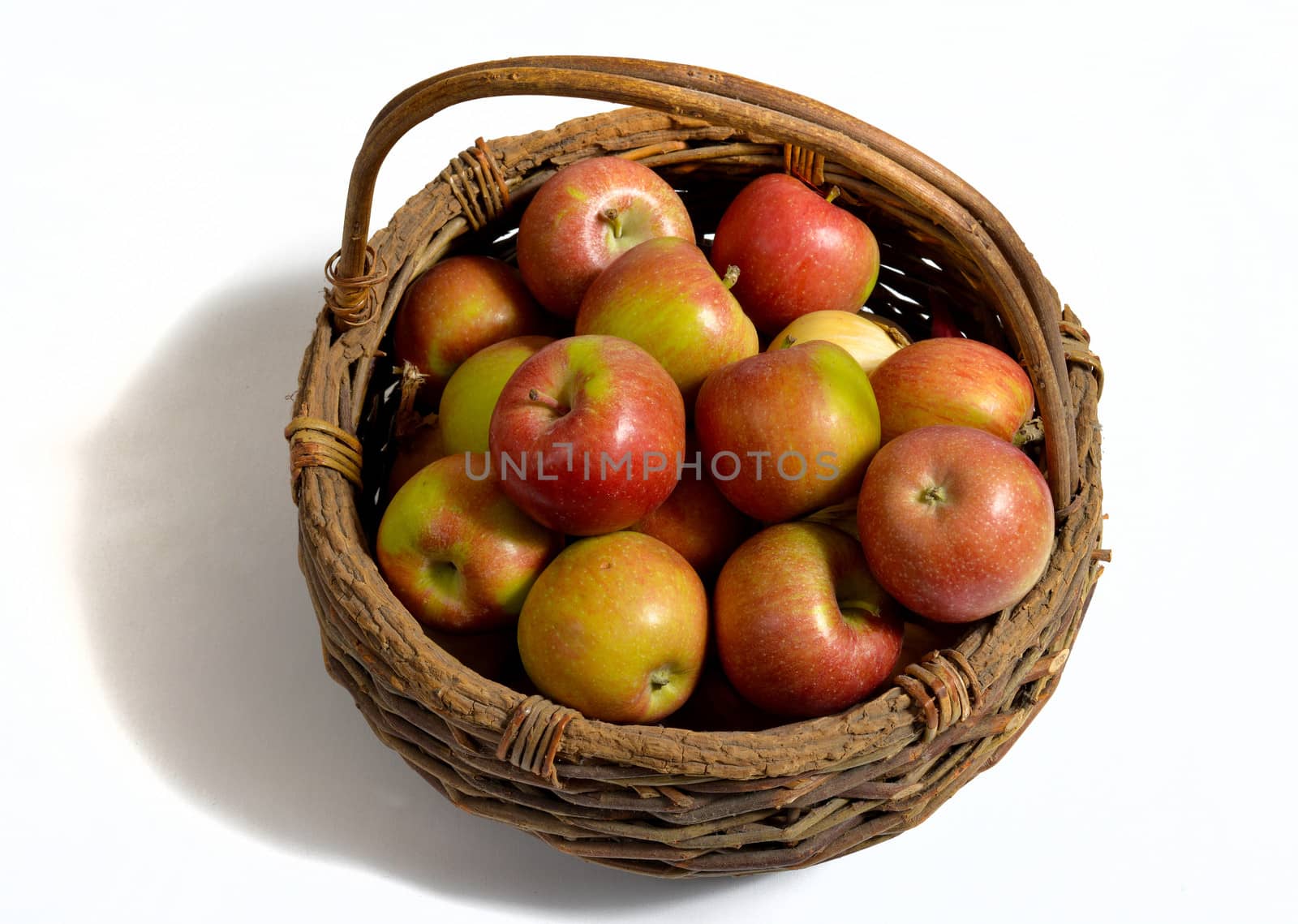 basket of apples with a bottle of Norman cider, isolated on a white background
