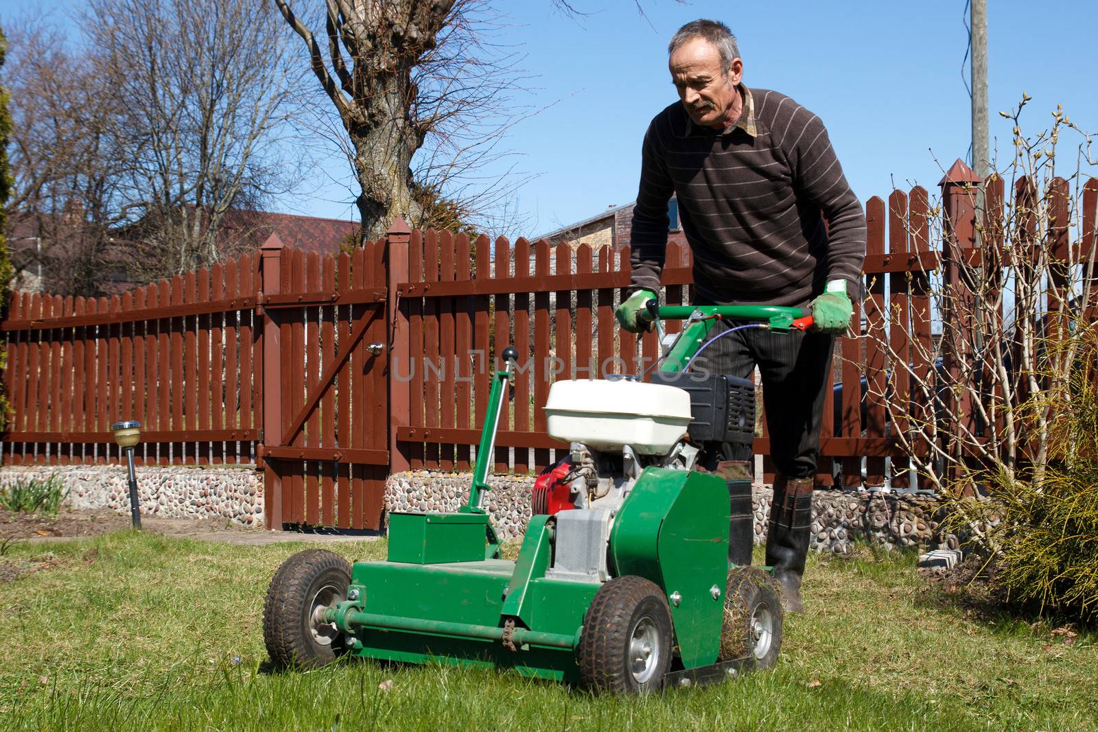 Spring work in garden. Man work with Man working with Lawn Aerator