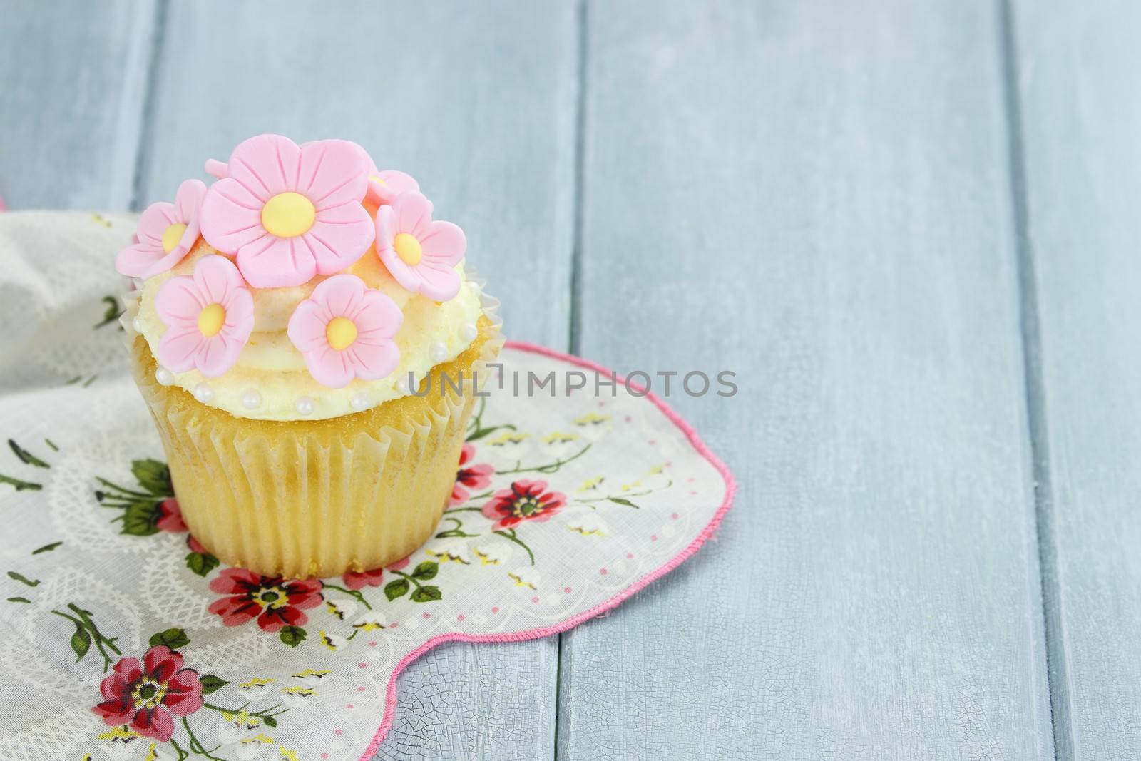 Pretty yellow and pink cupcake with extreme shallow depth of field and copy space.