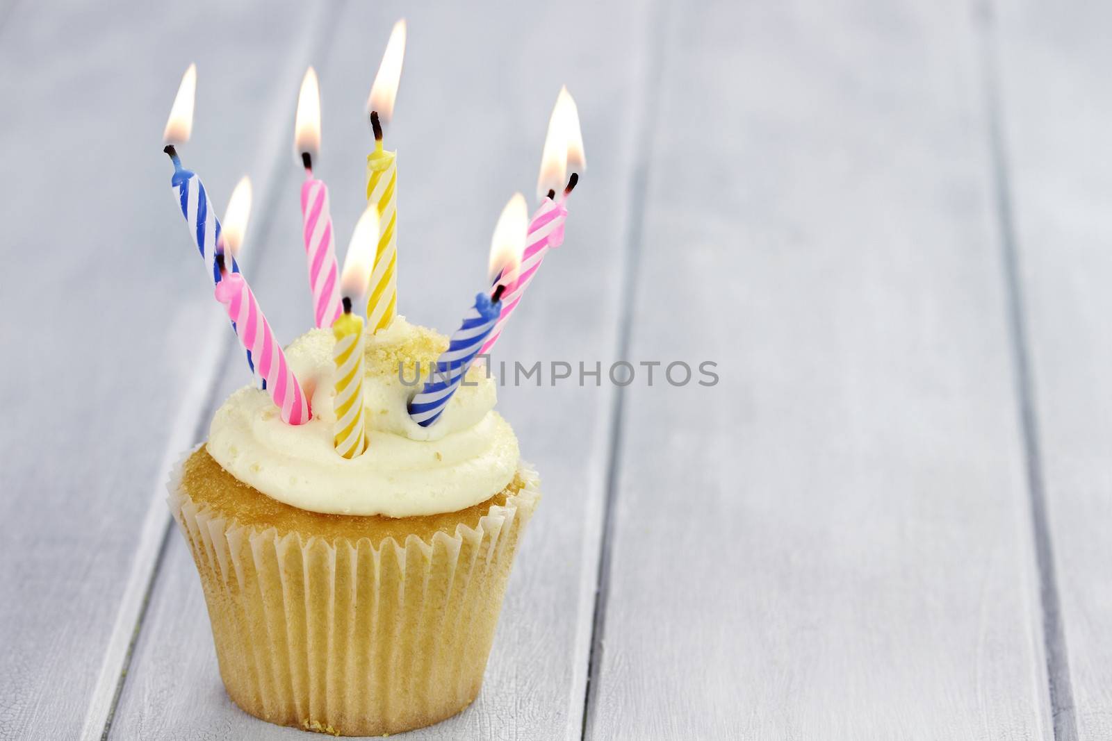 Birthday cupcake with eight burning candles and copy space.