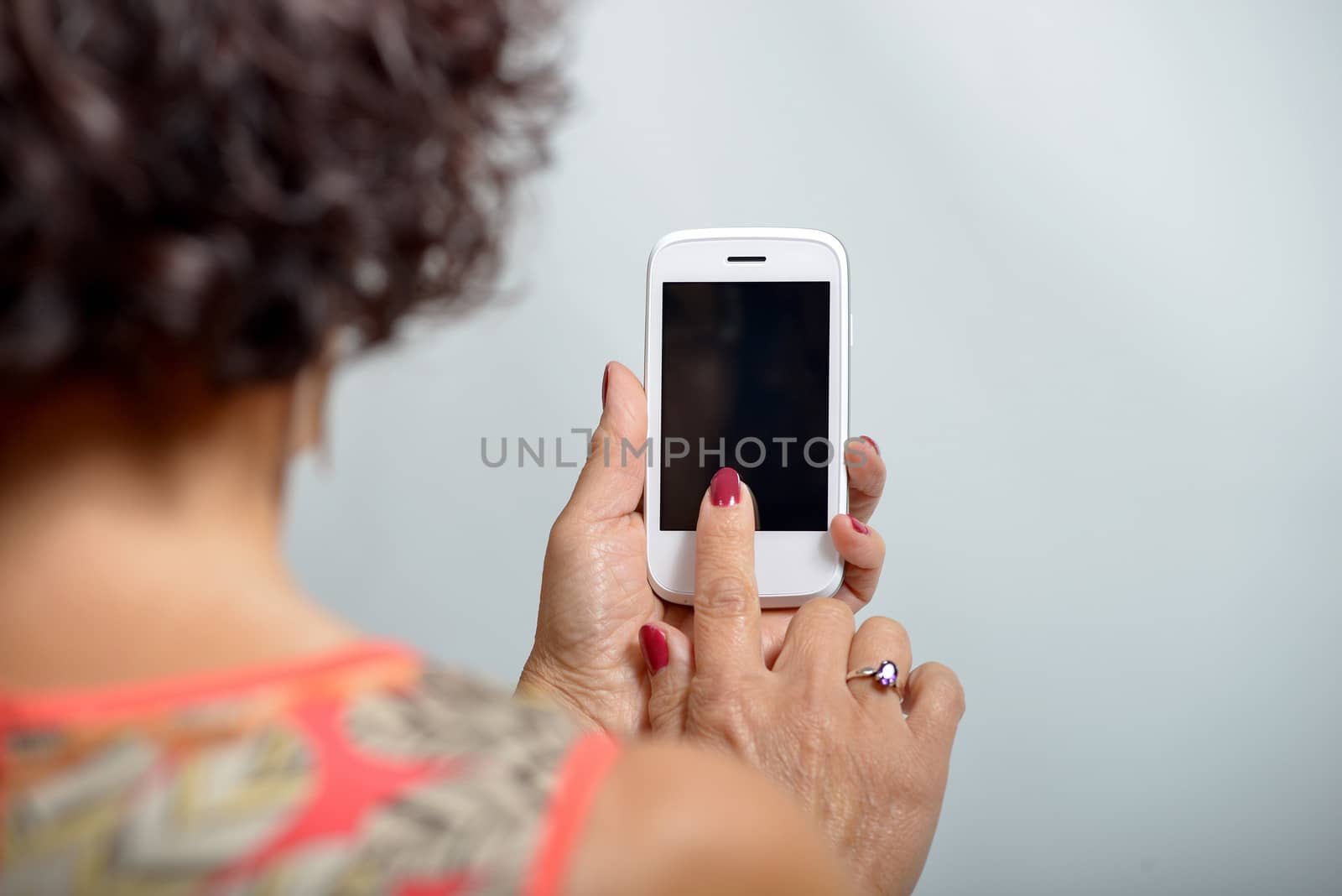 Young woman holding a mobile phone in the hand by philipimage