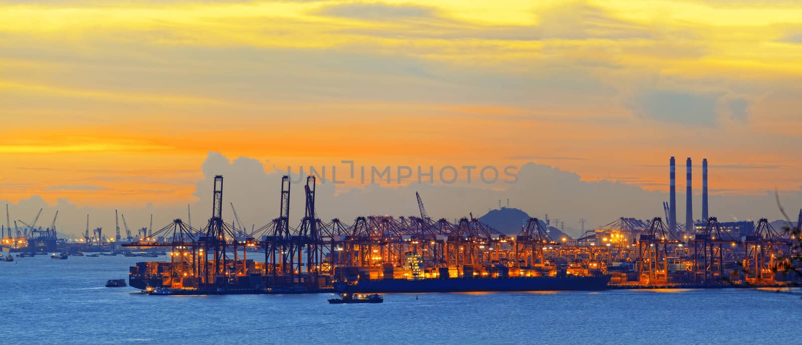 Silhouette of several cranes in a harbor, shot during sunset.