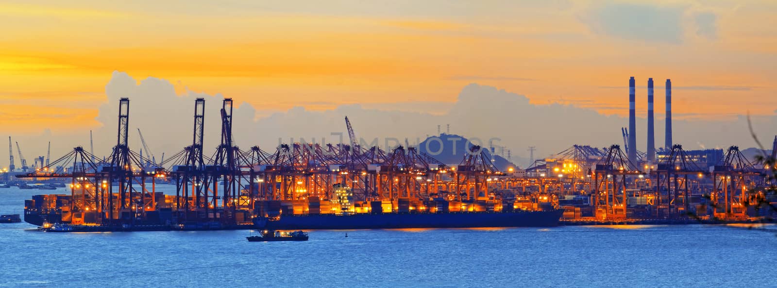 Silhouette of several cranes in a harbor, shot during sunset.