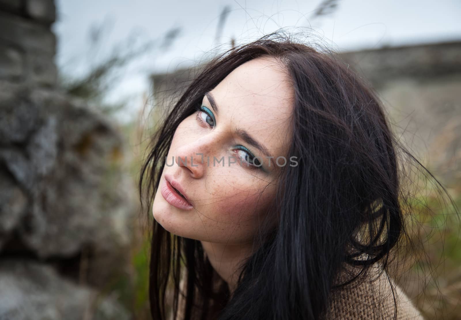 Portrait of a girl against background of nature and old concrete wall