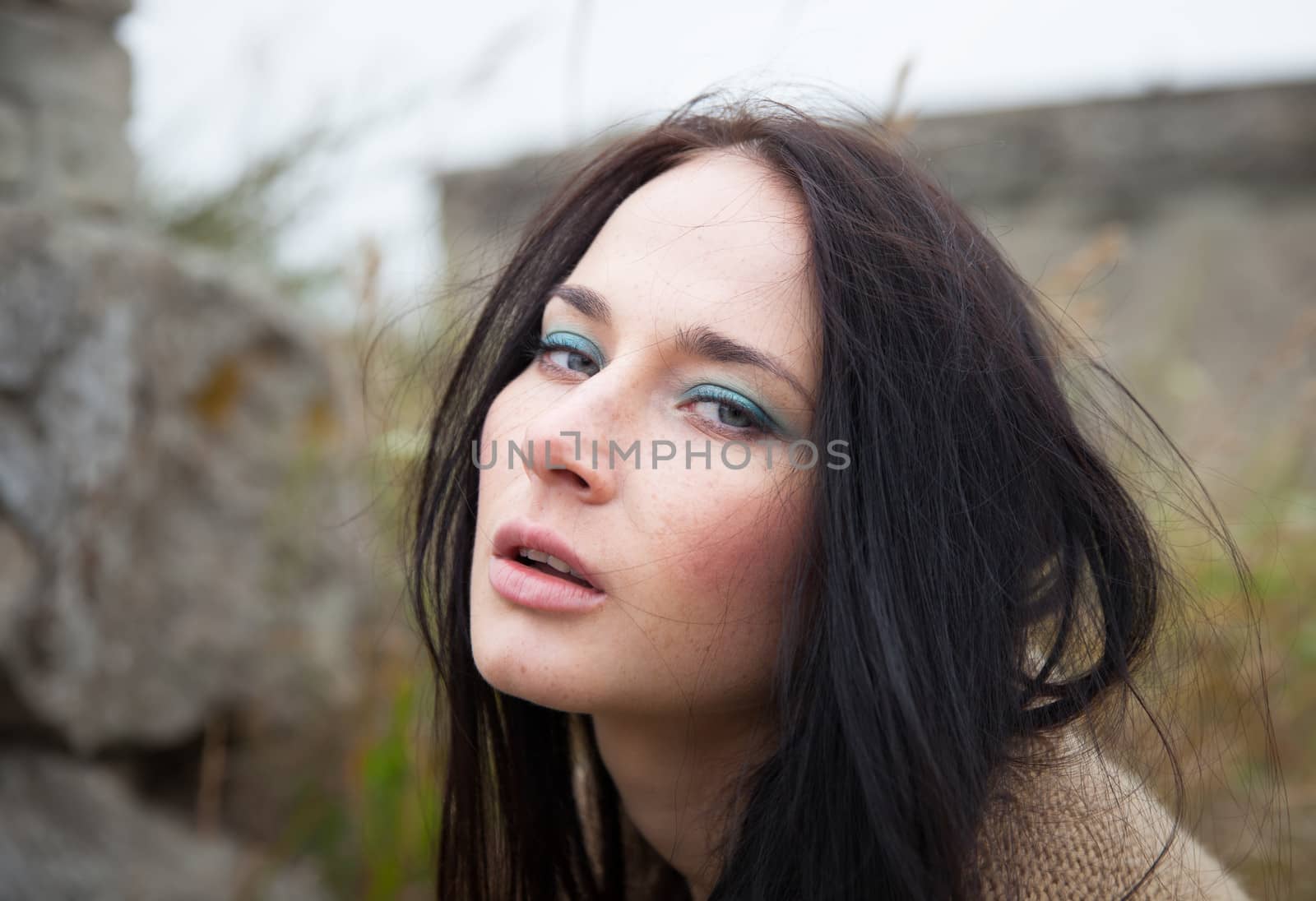 Portrait of a girl against background of nature and old concrete wall