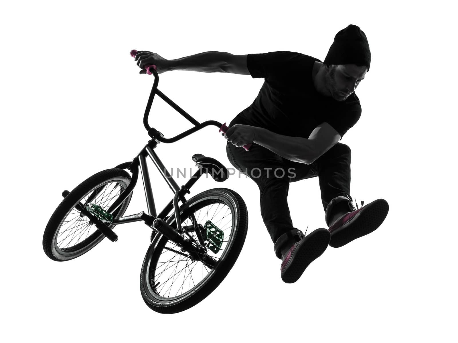 one caucasian man exercising bmx acrobatic figure in silhouette studio isolated on white background