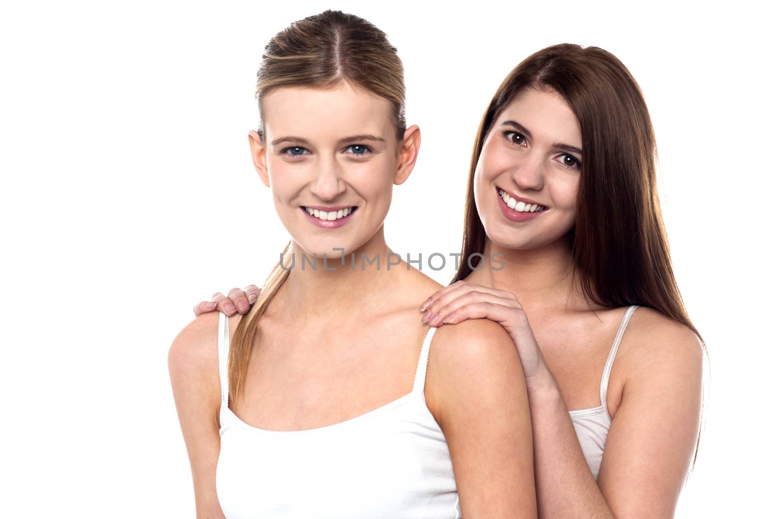 Two attractive girls posing in sleeveless spaghetti by stockyimages