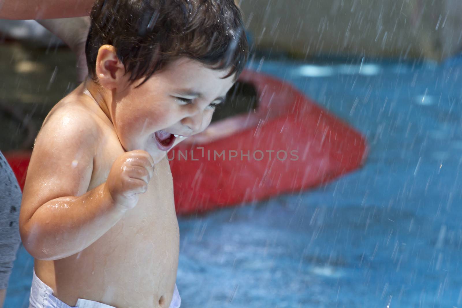 Kid playing in the pool, funny boy in summer